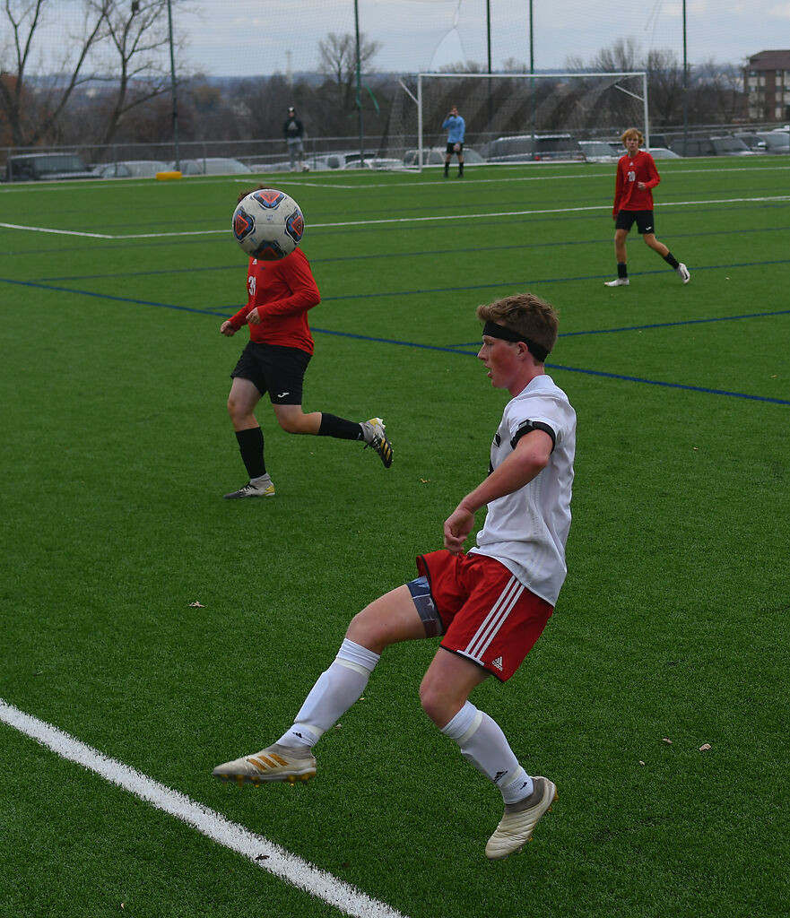 New Covenant Academy High School midfielder Dake Winslow, center, keeps the ball in play